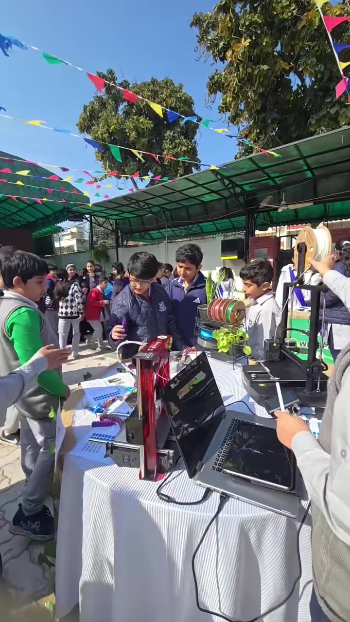 Students gathered around live 3D printers at a school exhibition
